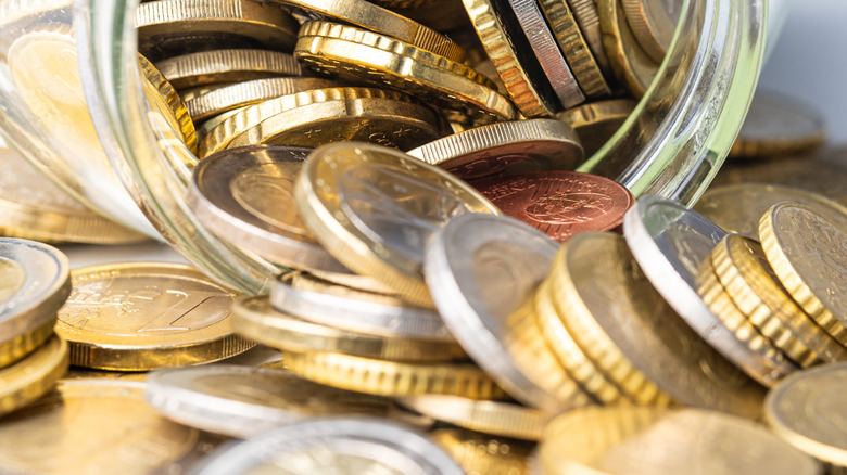 close up shot of coins spilling out of a glass mason jar