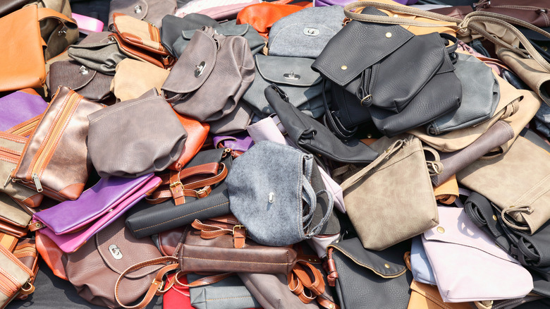 large pile of purses of all different styles and colors