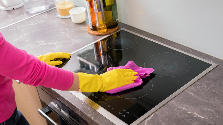 Woman cleaning glass cooktop