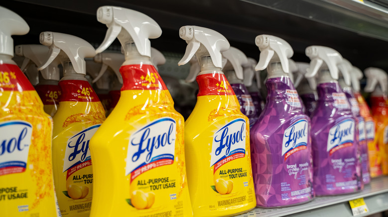 Yellow and purple bottles of Lysol spray on a store shelf