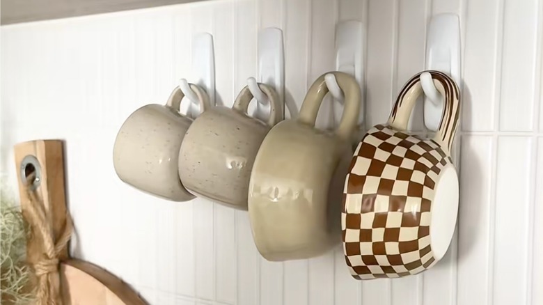 Mugs hanging from Command hooks on kitchen wall