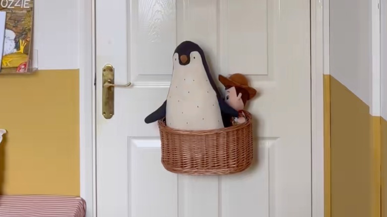 Toys in hanging basket behind door