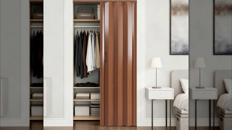 Walnut wood-like PVC accordion door partially opened over small closet in modern bedroom