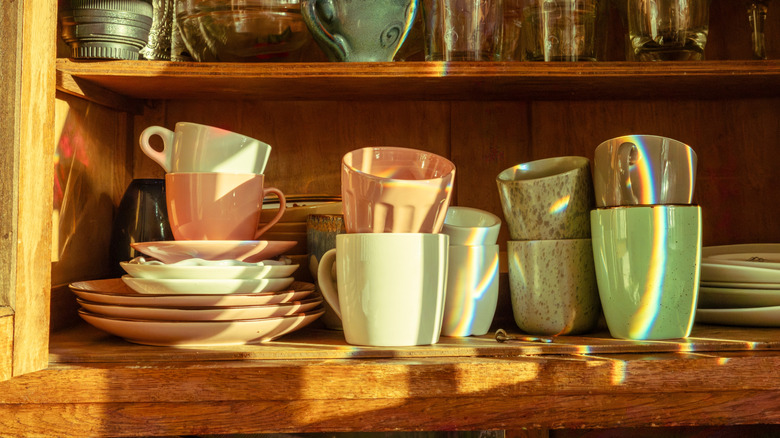 Mugs and teacups stored in a kitchen cabinet