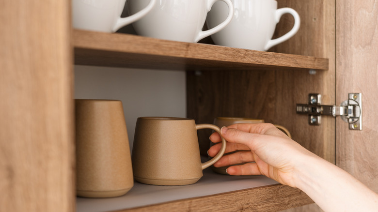 Hand reaching for coffee mug.