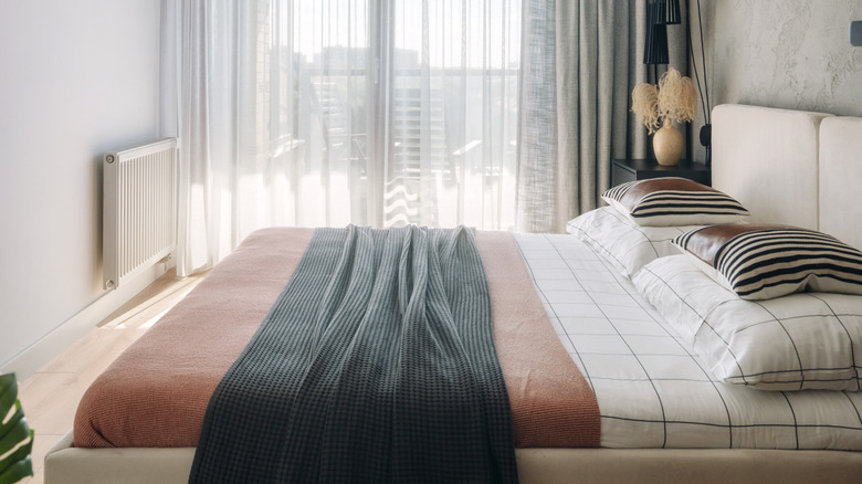 small bedroom with large bed and modern linens