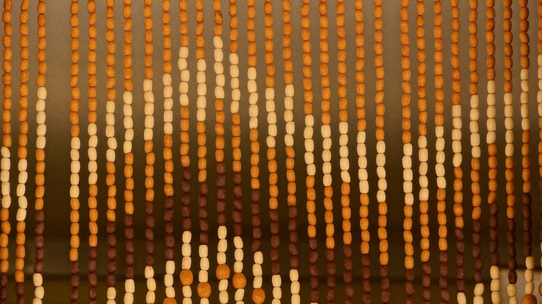 A chevron-effect brown beaded curtain is shown in detail