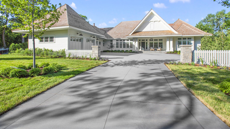 A large suburban home with a smooth concrete driveway with stamped borders.