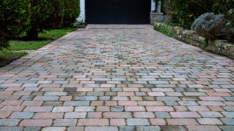 A residential driveway made with pavers of multiple colors.