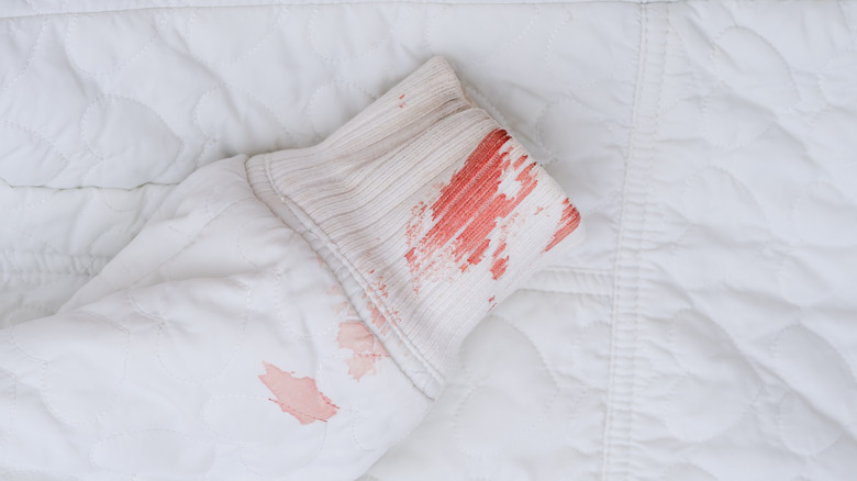 A white sweatshirt sleeve with blood stains on the cuff.