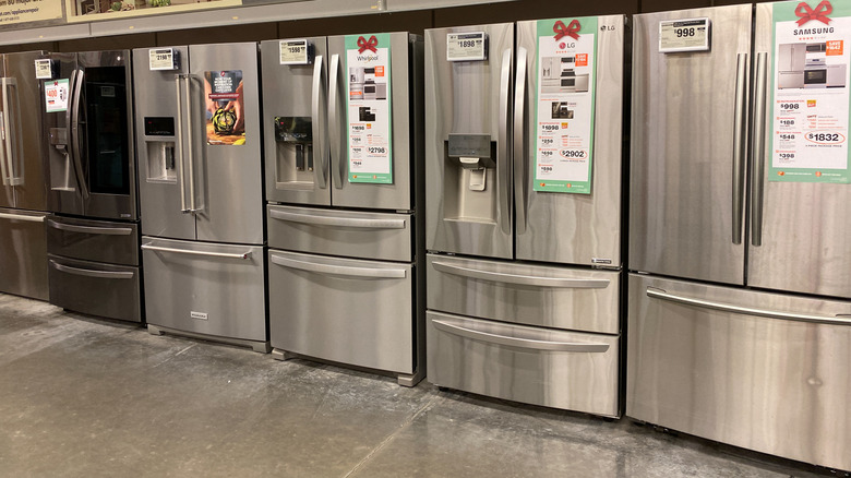 A row of French door refrigerators at a store.