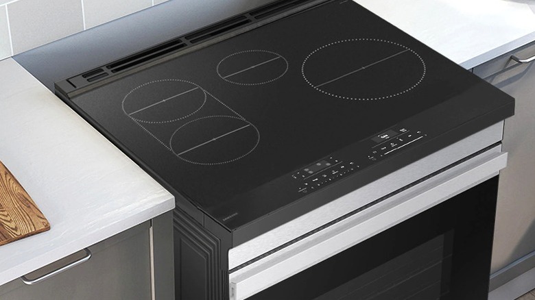 Samsung induction range installed in kitchen between light countertops