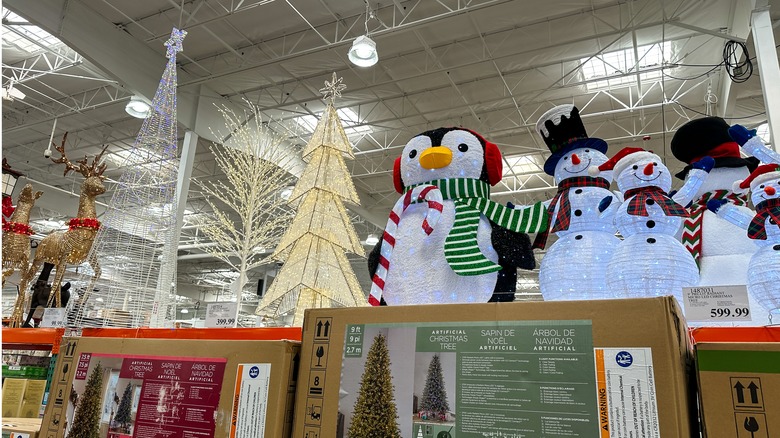 A selection of Costco holiday decor including light up trees, reindeer, snowmen, and penguins