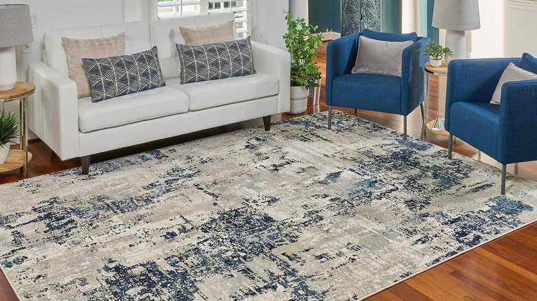 living room with blue and white furniture and similar colored distressed styled area rug
