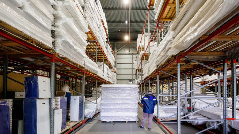 A stack of mattresses sitting in the aisle of a warehouse