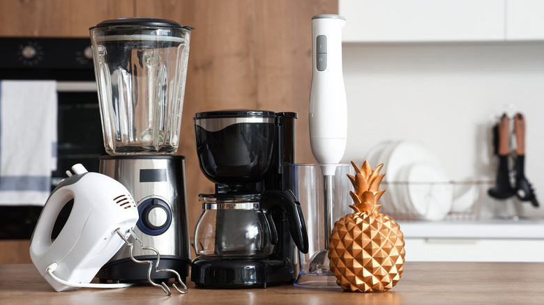 Hand mixer, blender, coffeemaker, and immersion blender sitting on a kitchen counter