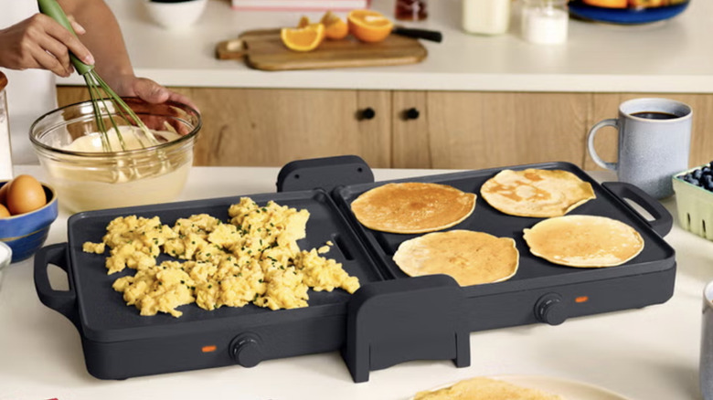 The bella Fold and Store Griddle with eggs and pancakes on a kitchen countertop with other breakfast foods.