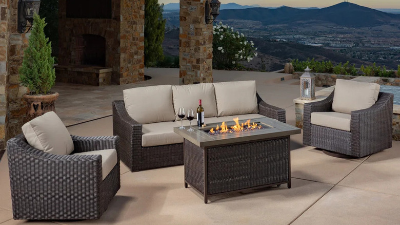 A firepit roars in front of a set of patio furniture