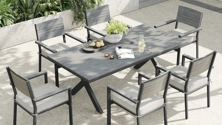 Patio chairs surround a large outdoor dining table