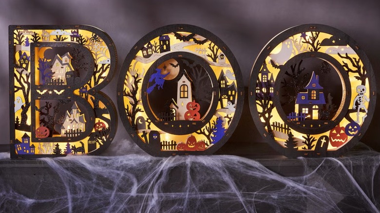 Wooden letters with embedded Halloween scenes arranged to read "Boo"