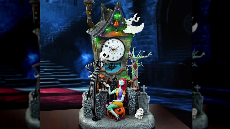 A LED lit clock tower with Jack Skellington, Zero, and Sally miniatures in the front