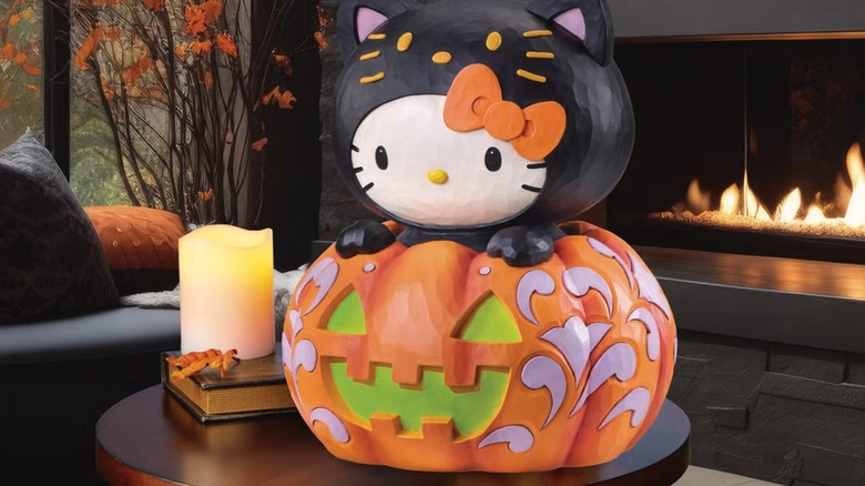A black-painted kitty coming out from a jack-o'-lantern