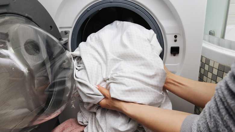 Person pulling sheets out of the washer