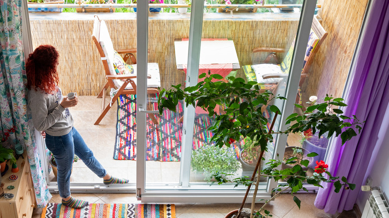 A woman stands in the opening of a sliding glass door