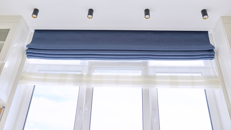 Two layers of Roman-style shades pulled up at the top of windows or doors