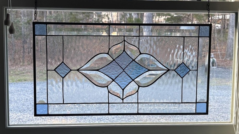 Stained glass transom panel hanging in a window