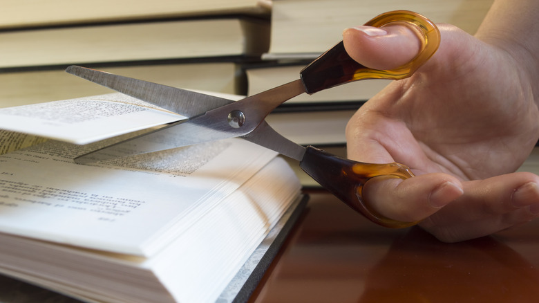 Hand cutting pages in a book
