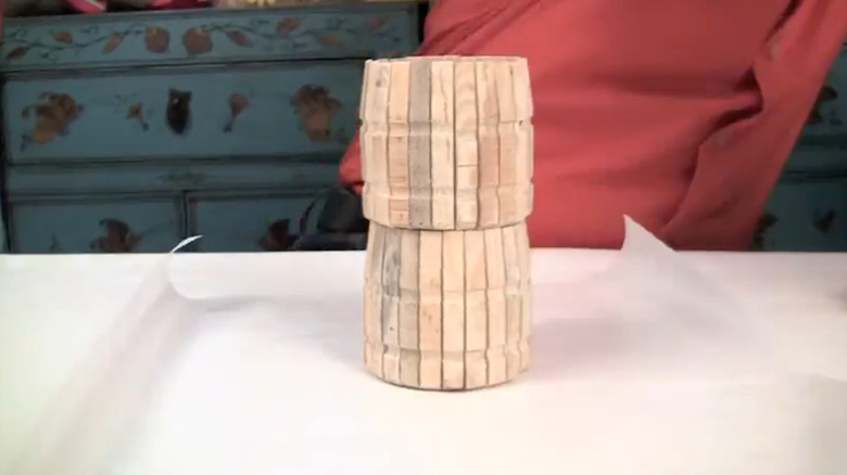 A jar covered in wooden clothespins