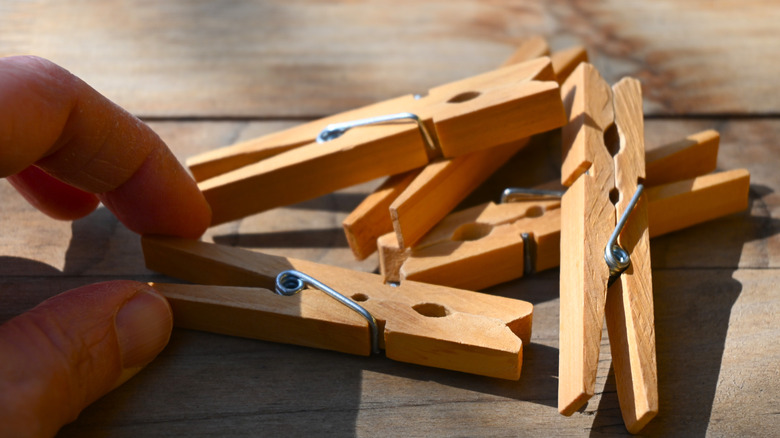 hand reaching for wooden clothespins