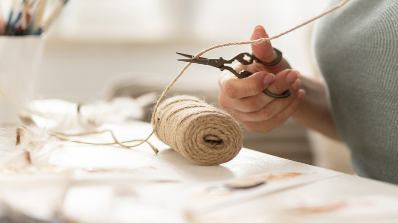 Woman cutting jute cord for crafting project