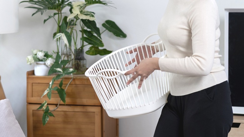 Person holding an old laundry basket