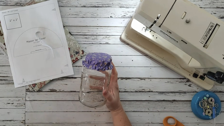 Hand holding jar with elastic fabric bonnet