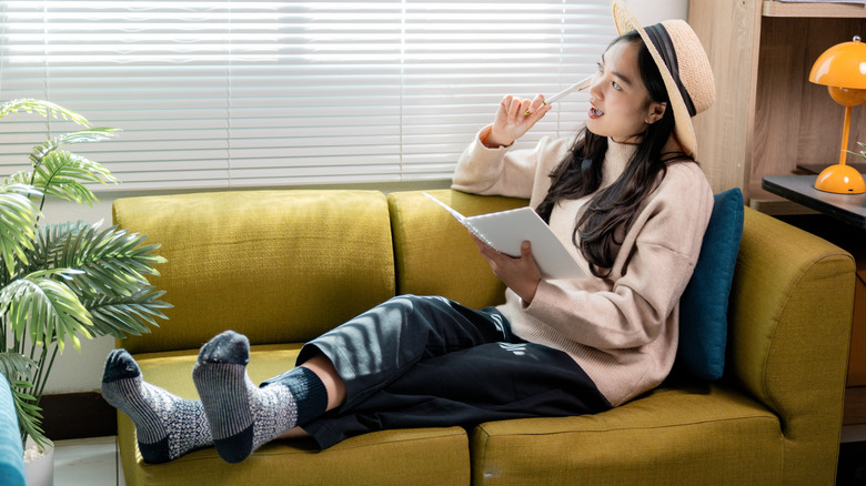 Young woman wearing socks sitting on couch