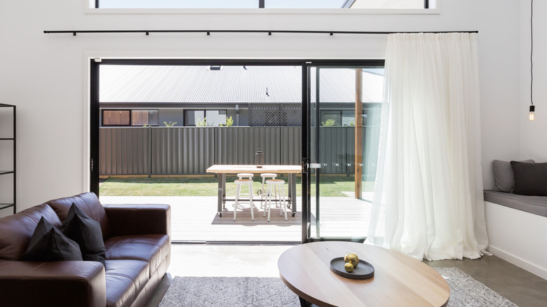 modern living room sliding door with sheer white curtain