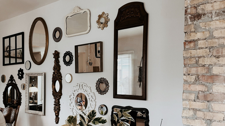 Gallery wall of framed mirrors in a home with brickwork