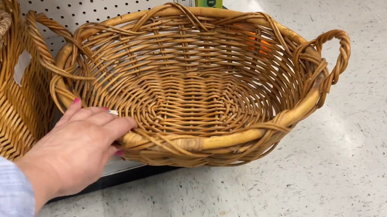 Woman grabbing for a basket on a thrift store shelf