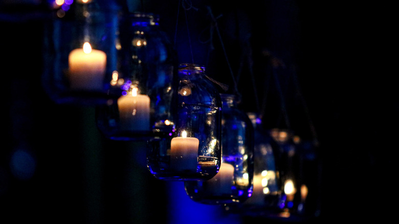 Hanging glass jars with lit candles inside