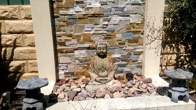 A fountain made of concrete blocks and decorated with stones and statues
