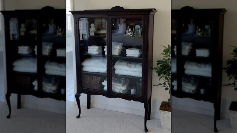Curio cabinet used as bathroom linen storage