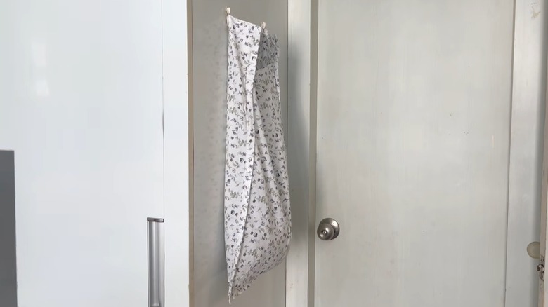 Subtle, stylish laundry bag hanging on hooks in white room