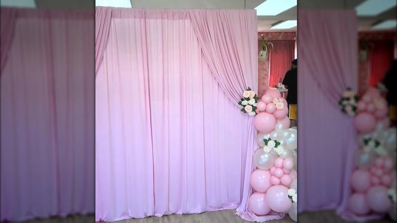 Elegant pink curtains repurposed as creative photo backdrop for house event