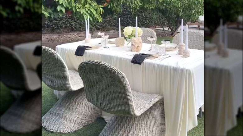 Outdoor dining area with classy setup and draped white curtains repurposed as tablecloth