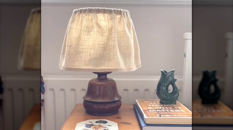 Vintage lamp with linen curtain lampshade beside traditional decor