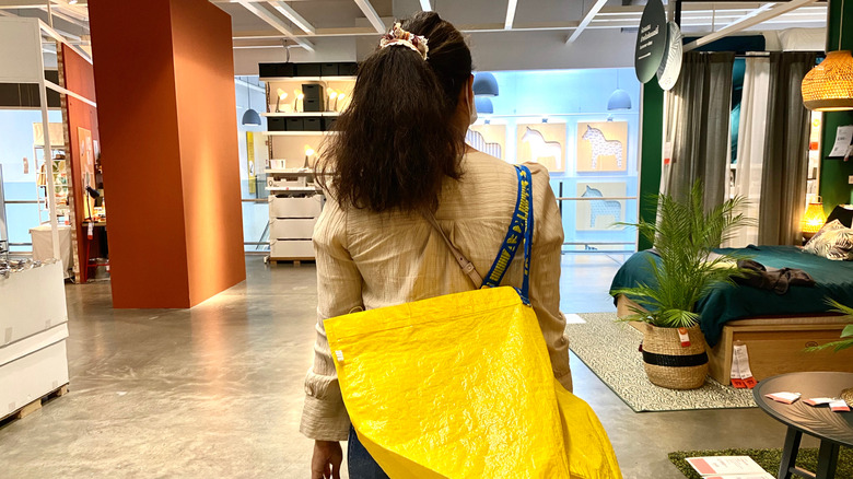 A person shopping at IKEA with a yellow bag