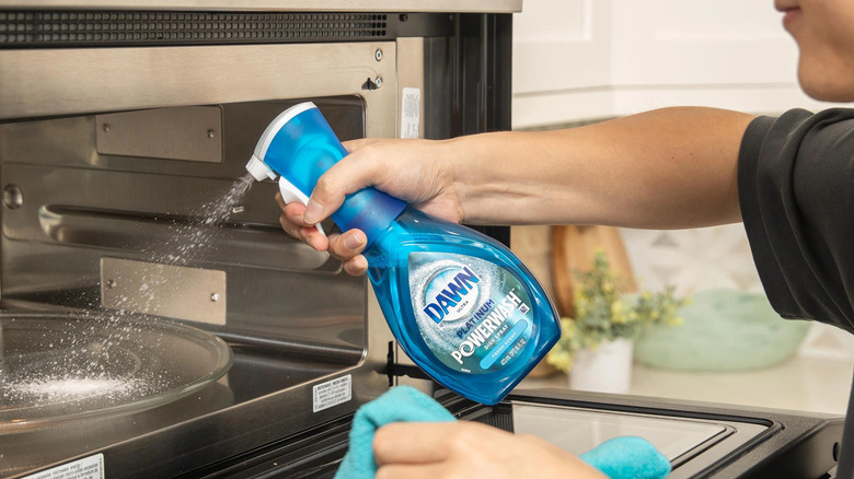 Man spraying Dawn Powerwash in an oven