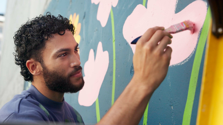 A man painting a wall with a brush